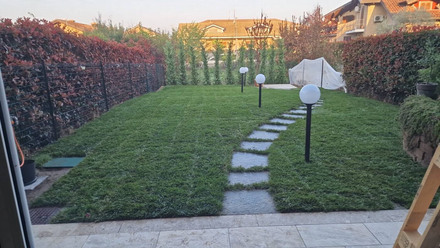 Prato con camminamento in pietra e lampioncini