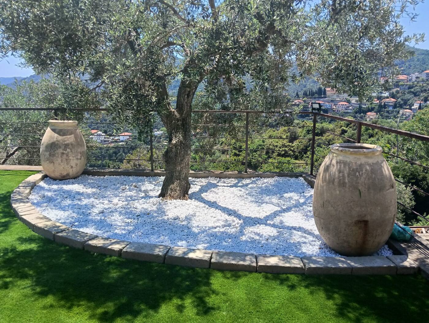 Terrazzo con ulivo, prato e ghiaia bianca